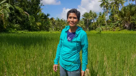 Woman in light blue jumper standing on green field